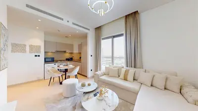 a living room with a white couch and a table at Creek Vistas - Elegant One Bedroom in Meydan in Dubai