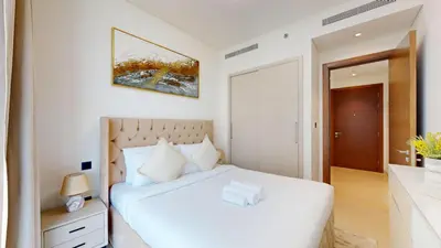 a white bedroom with a white bed and a mirror at Creek Vistas - Elegant One Bedroom in Meydan in Dubai