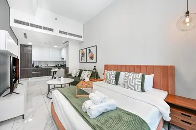 a bedroom with a large bed and a living room at Modern Studio Steps from Iconic Dubai Mall & World-Class Amenities in Dubai