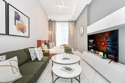a living room with a couch and a tv at Modern Studio Steps from Iconic Dubai Mall & World-Class Amenities in Dubai