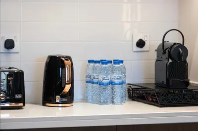 a bunch of bottles of water sitting on a counter at Stunning 4BR with Burj Khalifa and Fountain View, Downtown Dubai in Dubai