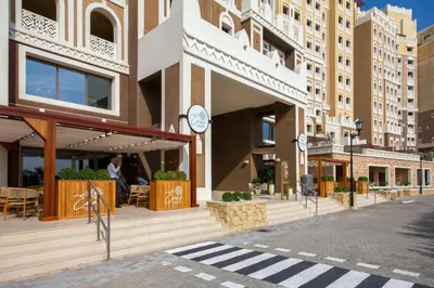 a building with a clock on the side of it at Bespoke Holiday Homes - Spacious 2BR Luxury Apartment with Stunning Palm Views, Balqis in Dubai