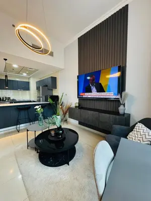 a living room with a tv and a couch and a table at Bay Central Sea and Canal View, Dubai Marina in Dubai
