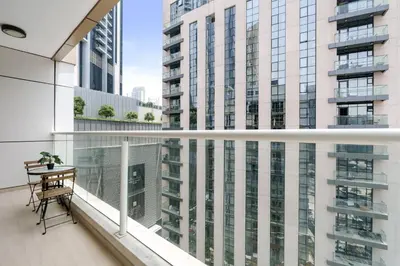 a balcony with a table and some tall buildings at Neat and Cozy 2BR plus Kids Room - 7min to Dubai Mall in Dubai