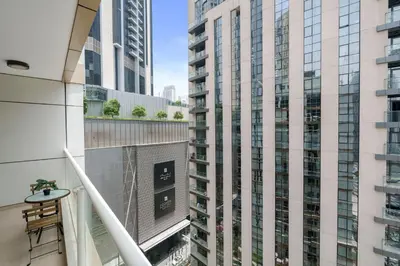 a balcony with two tall buildings at Neat and Cozy 2BR plus Kids Room - 7min to Dubai Mall in Dubai