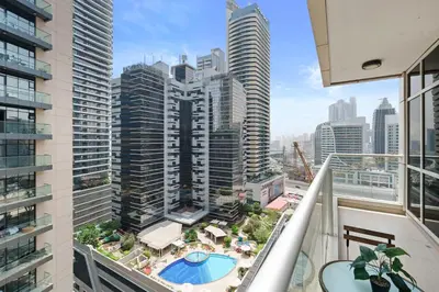 a balcony with a view of a pool and buildings at Neat and Cozy 2BR plus Kids Room - 7min to Dubai Mall in Dubai