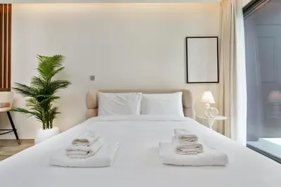 a bedroom with a large white bed with towels on it at Cloud 18 Studio - Business Bay in Dubai