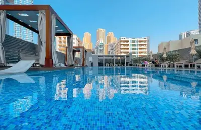 a large blue swimming pool with buildings in the background at Sophisticated Fully Furnished and Family-Friendly in Dubai