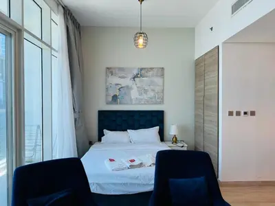 a bedroom with a bed with two chairs at Sophisticated Fully Furnished and Family-Friendly in Dubai