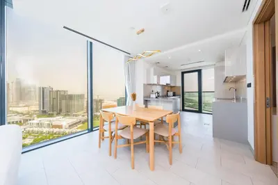 a kitchen and dining room with a table and chairs at Modern Living with Skyline Views in Hartland in Dubai
