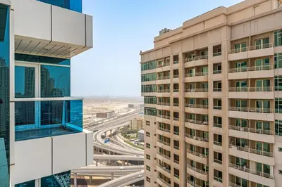 an aerial view of two tall buildings and a highway at 2BR with Marina Views - Near JBR Beach & Dubai Eye in Dubai