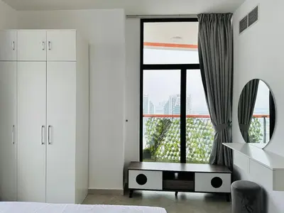 a bedroom with white cabinets and a large window at Fully Furnished and High Floor Unit in Al Jaddaf in Dubai