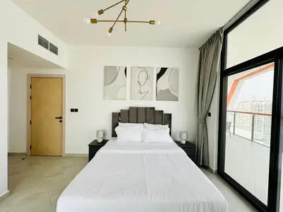 a bedroom with a large white bed and a window at Fully Furnished and High Floor Unit in Al Jaddaf in Dubai