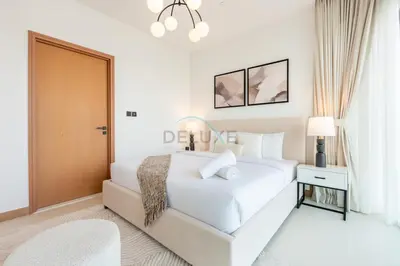 a white bedroom with a large white bed and a chandelier at High Rise Apartment with Direct Access to Marina Walk, Near JBR, Marina Mall and Dubai Dining Hotspots, VIDA Residences, Dubai Marina by Deluxe Holiday Homes in Dubai