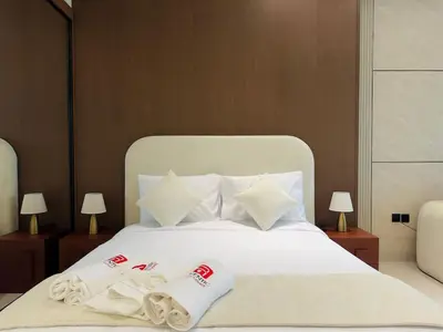 a bedroom with a bed with two towels on it at Brand New with Private Jacuzzi in Dubai