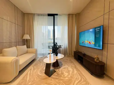 a living room with a couch and a flat screen tv at Brand New with Private Jacuzzi in Dubai