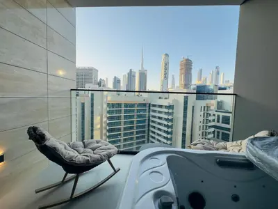a bedroom with a bed and a view of a city at Brand New with Private Jacuzzi in Dubai