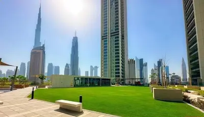 a park in the middle of a city with tall buildings at Zabeel View I Fully Furnished I Prime Location in Dubai