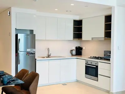 a kitchen with white cabinets and a stainless steel refrigerator at Zabeel View I Fully Furnished I Prime Location in Dubai