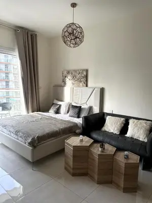 a bedroom with a bed and a couch at Best Canal View Studio in AG Tower Business Bay in Sabkhah