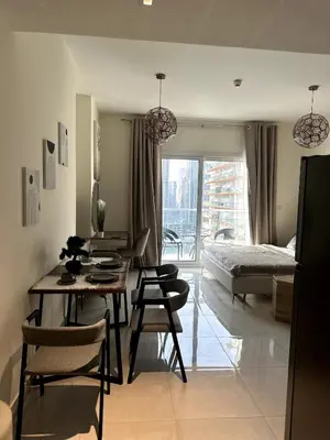 a living room with a table and chairs and a bed at Best Canal View Studio in AG Tower Business Bay in Sabkhah
