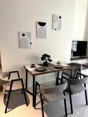 a dining room table and chairs in a room at Best Canal View Studio in AG Tower Business Bay in Sabkhah