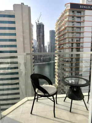 a chair and a table on a balcony with a view at Best Canal View Studio in AG Tower Business Bay in Sabkhah