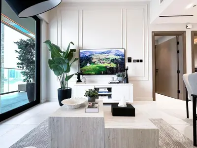 a living room with a tv on a wall at 1-Bedroom Apartment in Downtown with Pool View in Dubai