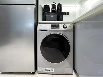 a washing machine in a kitchen next to a refrigerator at 1-Bedroom Apartment in Downtown with Pool View in Dubai