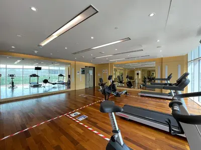 a gym with treadmills and exercise equipment in a room at The Smart Concierge - Damac 108 in Dubai