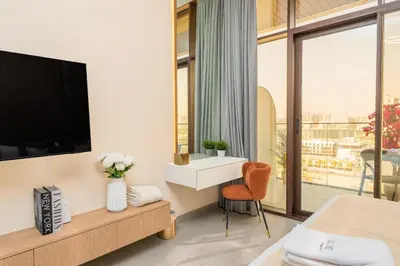 a bedroom with a tv and a bed and a window at Escape24 Cozy Studio with Infinity Pool in JVC in Dubai