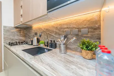 a kitchen counter with a sink and some plants at Escape24 Cozy Studio with Infinity Pool in JVC in Dubai