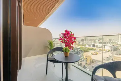 a balcony with a table and a view of a city at Escape24 Cozy Studio with Infinity Pool in JVC in Dubai
