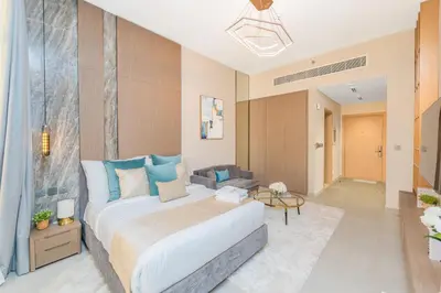 a bedroom with a large bed and a living room at Escape24 Cozy Studio with Infinity Pool in JVC in Dubai