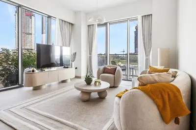 a living room with a couch and a tv at Jumeirah Waterfront Residences in Dubai