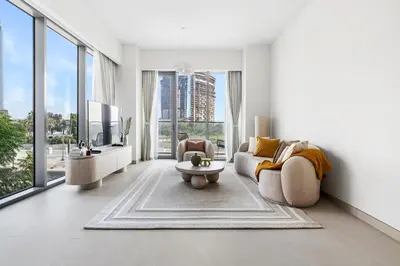 a living room with a couch and a tv at Jumeirah Waterfront Residences in Dubai