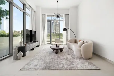 a living room with a couch and a tv at Jumeirah Waterfront Residences in Dubai