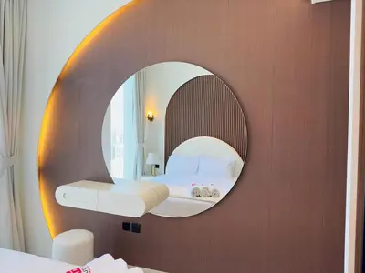 a bedroom with a circular mirror on a wall at High-End Furnished Homey Elegant with Private Pool in Dubai