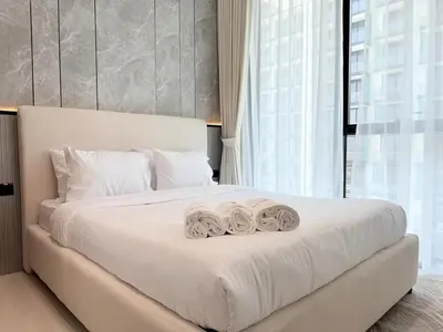 a bedroom with a large white bed with two towels at Brand New with Installed Private Pool in Balcony in Dubai