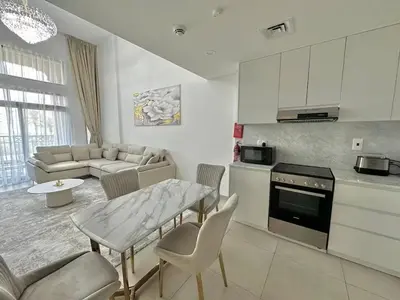 a kitchen and living room with a table and a couch at Luxurious Apartment in the Heart of Dubai in Dubai