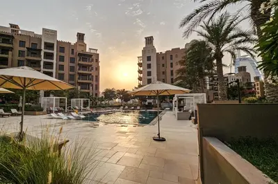 a pool with umbrellas in a city with buildings at Luxurious Apartment in the Heart of Dubai in Dubai
