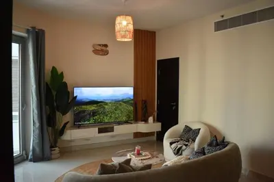 a living room with a flat screen tv on a wall at Cozy 2BR -Near JBR Beach &Metro in Dubai