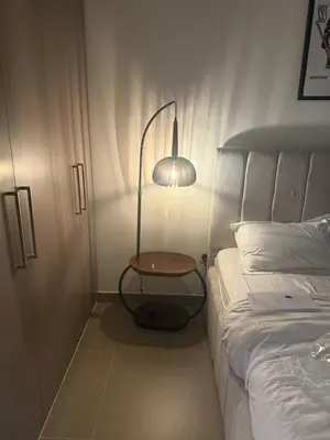 a bedroom with a lamp next to a bed at Giramondo Forte Tower 1 in Dubai