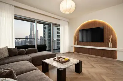 a living room with a couch and a flat screen tv at Seraya Residence 21 - 4BDR - Cozy terrace with Burj Views in Dubai