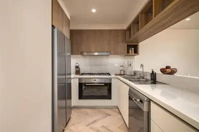 a kitchen with white counters and a stove top oven at Seraya Residence 21 - 4BDR - Cozy terrace with Burj Views in Dubai