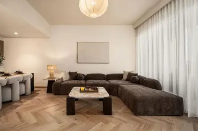 a living room with a couch and a table at Seraya Residence 21 - 4BDR - Cozy terrace with Burj Views in Dubai