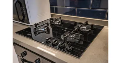 a stove top with a microwave on top of it at Stylish Studio - 5-min walk Burj Khalifa & Dubai Mall in Dubai