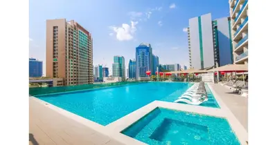 a swimming pool with a city skyline in the background at Stylish Studio - 5-min walk Burj Khalifa & Dubai Mall in Dubai