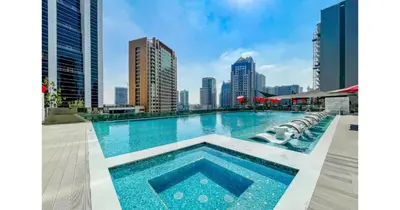 a swimming pool with a city skyline in the background at Stylish Studio - 5-min walk Burj Khalifa & Dubai Mall in Dubai
