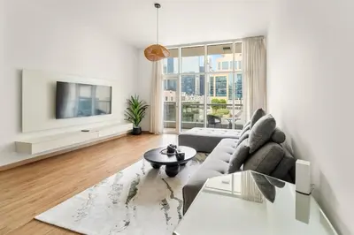 a living room with a couch and a tv at Dubai 1BR City Views, Near Downtown Dining, Culture & Attractions in Dubai